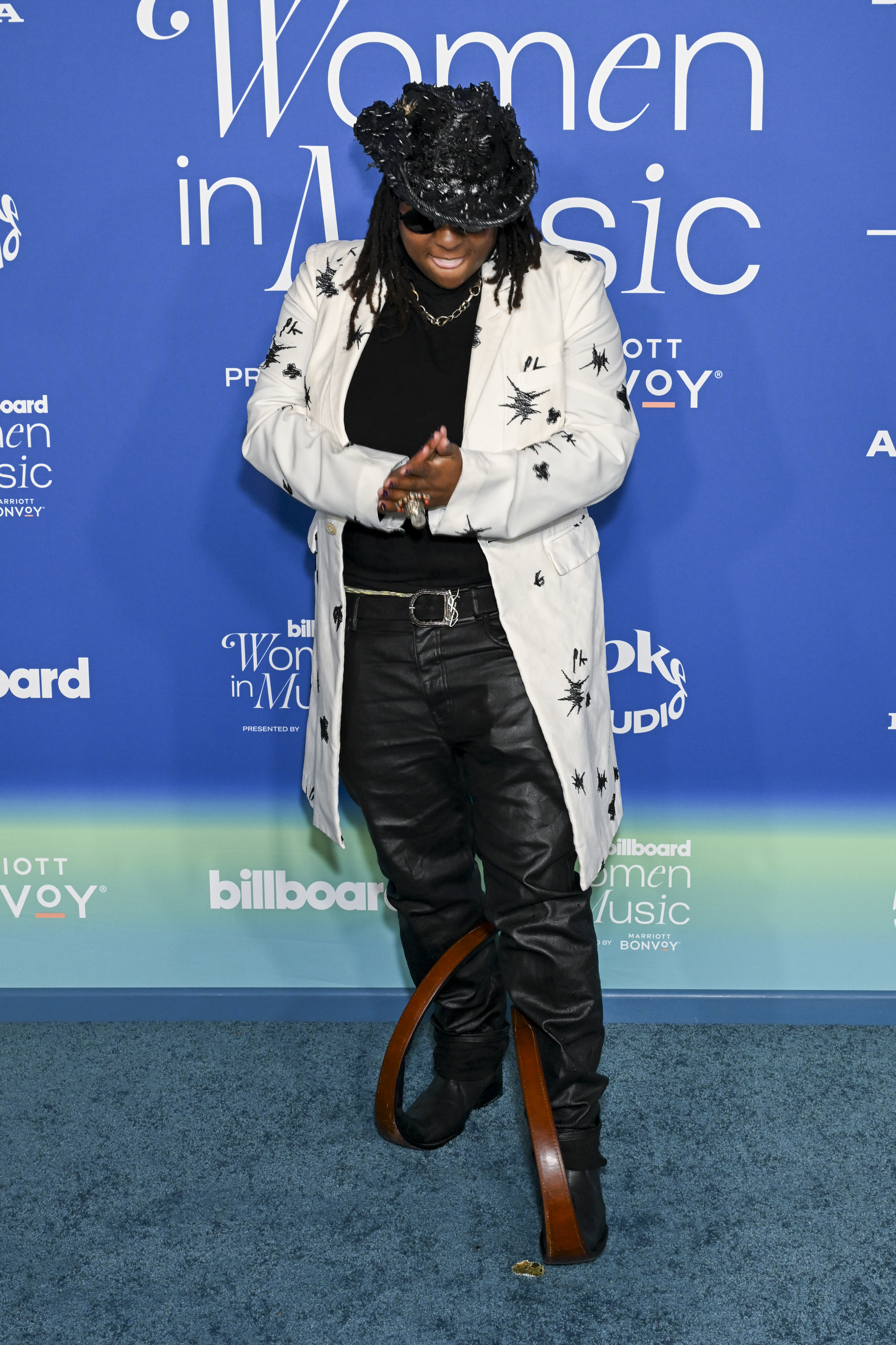 Ink in a long white jacket with star details, black hat, and boots that have a long curving toe