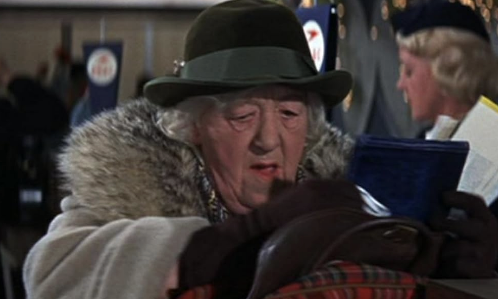 Character Marv, disguised as an older woman, holds a purse at an airport in &quot;Home Alone 2&quot;