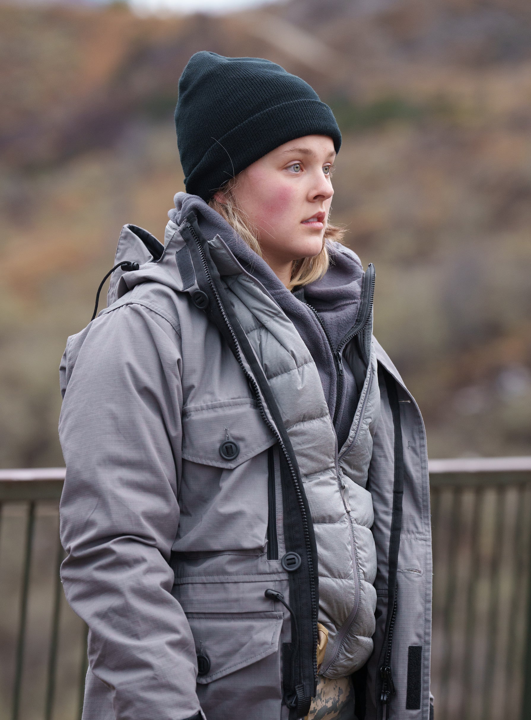 JoJo in warm outdoor layers with a beanie, standing outside