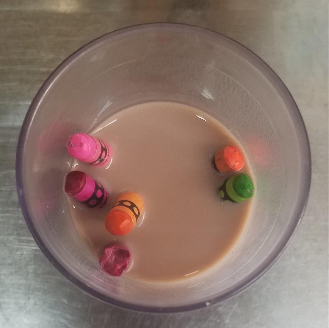 A glass of chocolate milk with colorful candy pieces floating on top