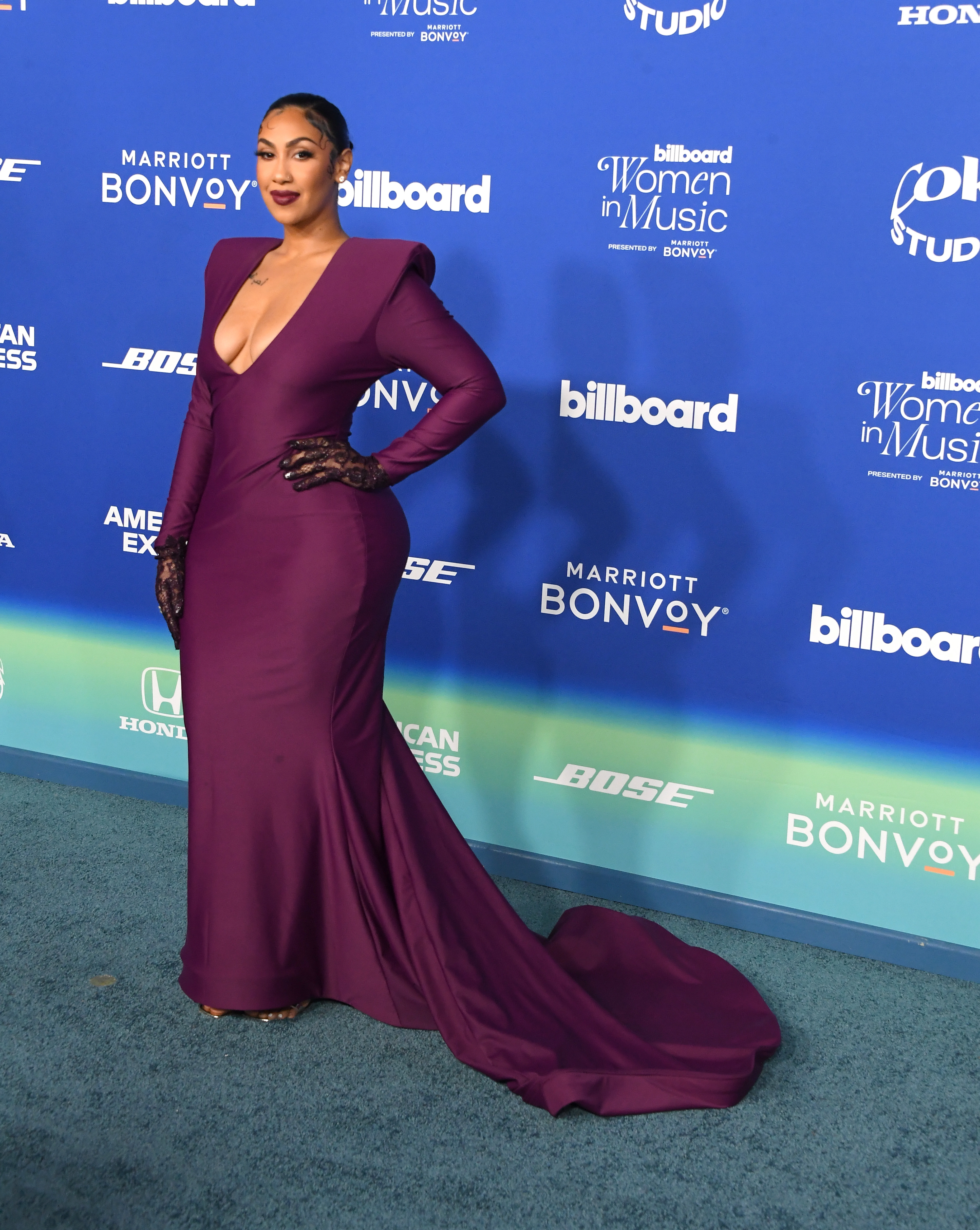 She&#x27;s in a long-sleeve gown with a plunging neckline and train