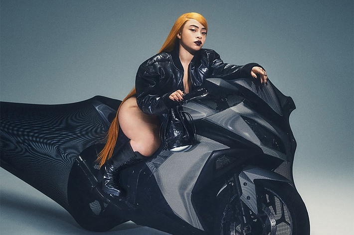 Woman in a glossy outfit posing on a motorcycle for an Alexander Wang advertisement