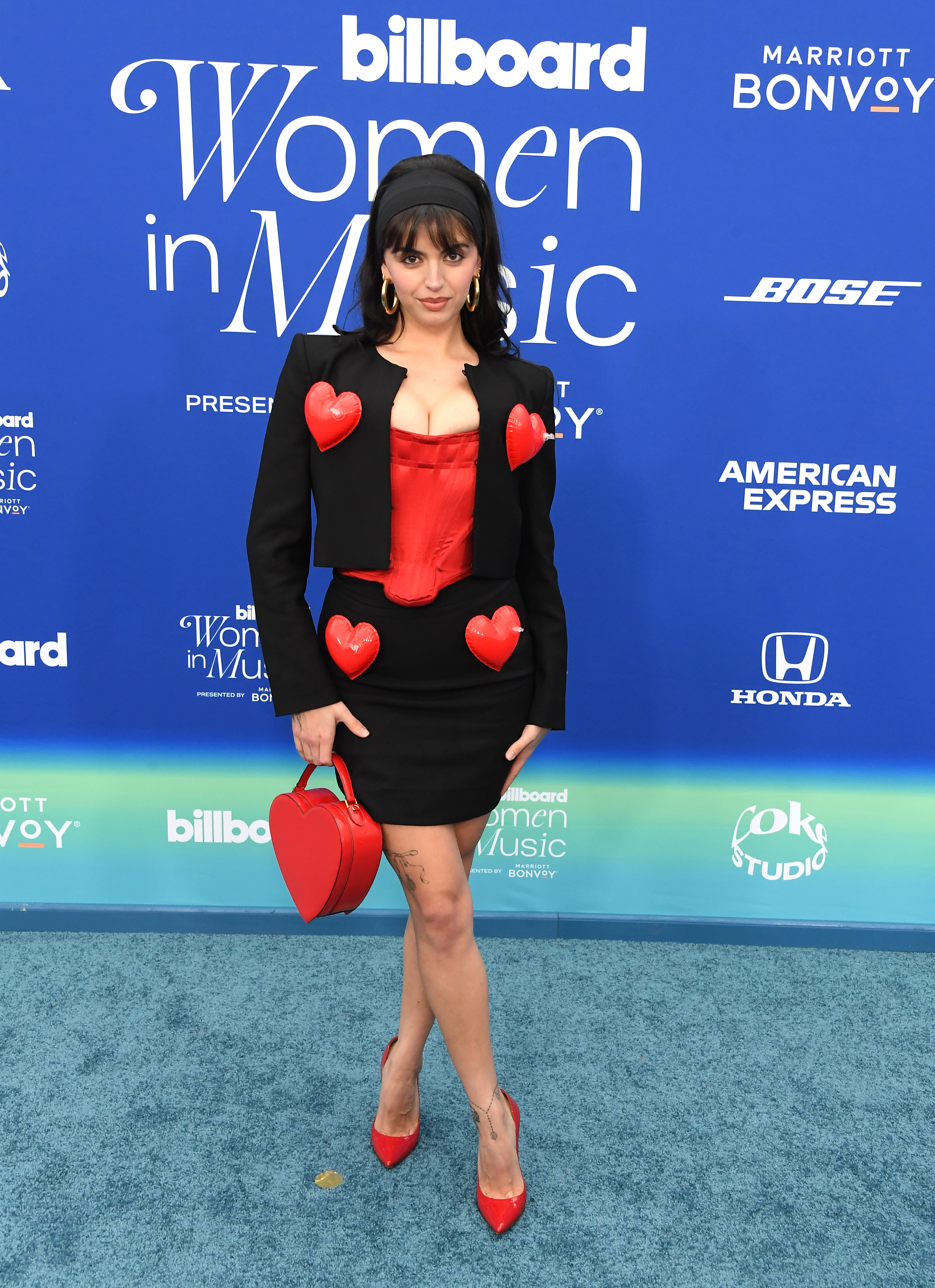 Rebecca in a  blazer and skirt with red heart accents and matching heart purse