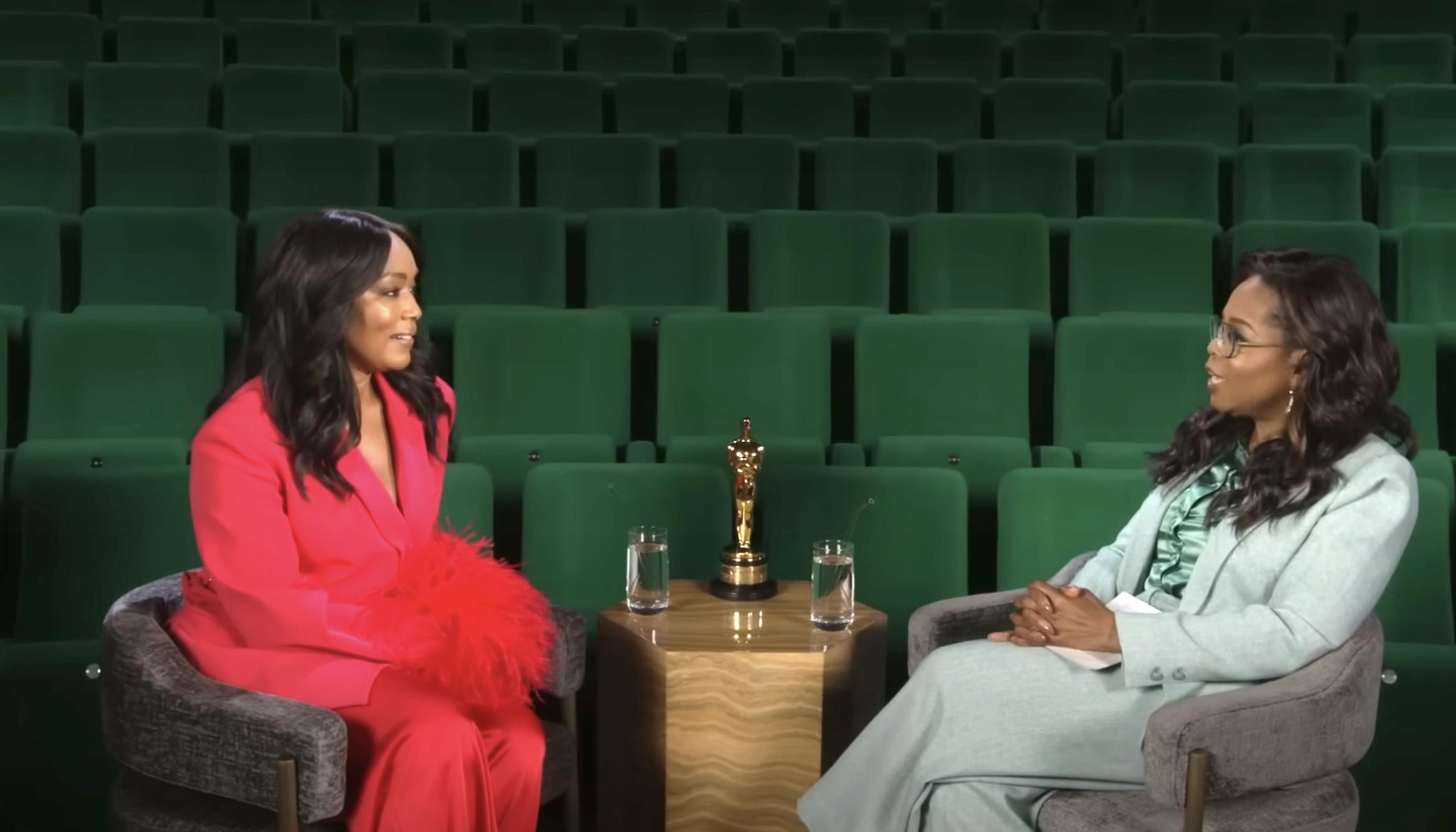 Angela and Oprah in conversation with an Oscar trophy on a table in between them
