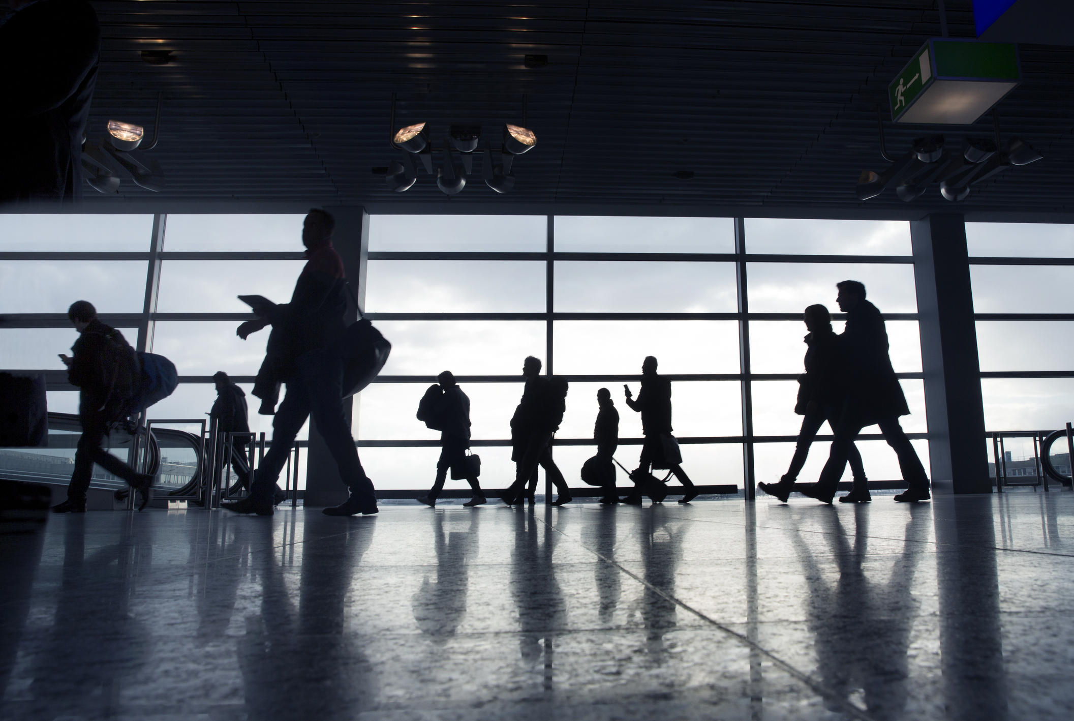 Silhouetted figures walking in an airport