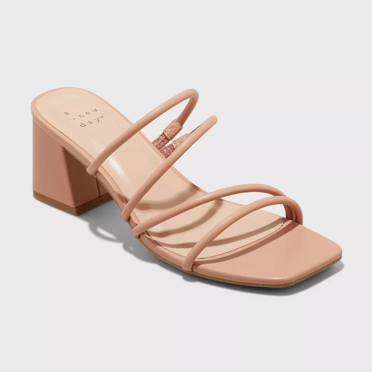 Strappy heeled sandal with a block heel on a solid background