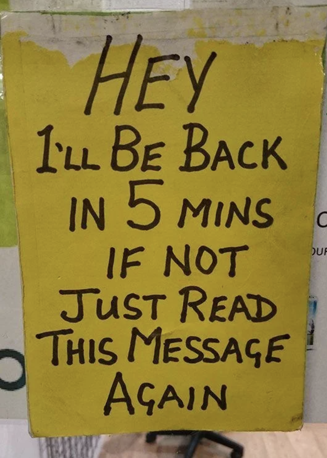 Handwritten sign saying "I'll be back in 5 minutes if not just read this message again"