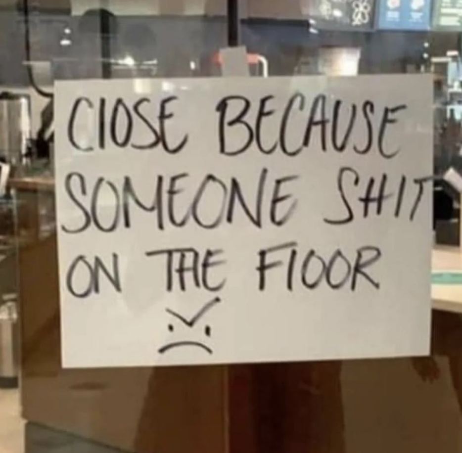 Handwritten sign saying a place is closed "because someone shit on the floor," with a sad face drawn below