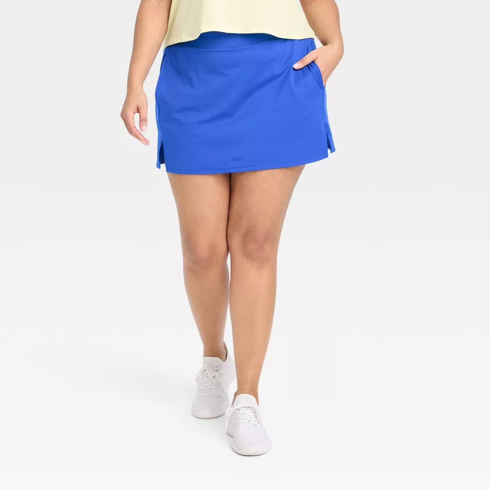 Model in a casual blue skirt and white sneakers, emphasizing the skirt&#x27;s fit and style for shopping context