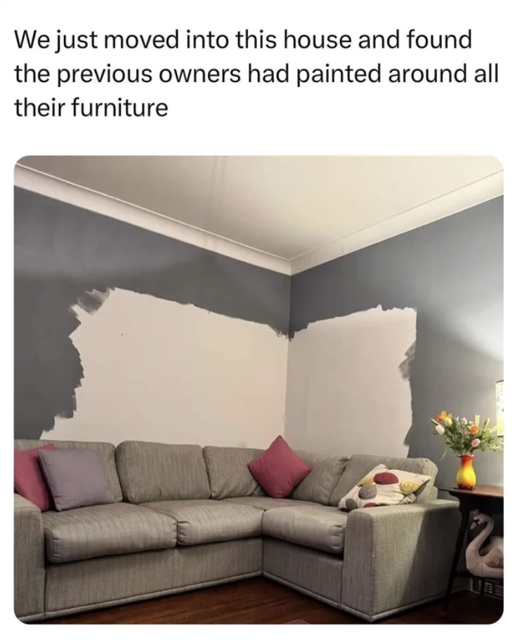A living room wall with uneven paint patches around a sofa, indicating the previous owners did not paint behind their furniture