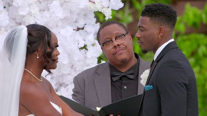 Bride and groom exchange vows with in front of an officiant