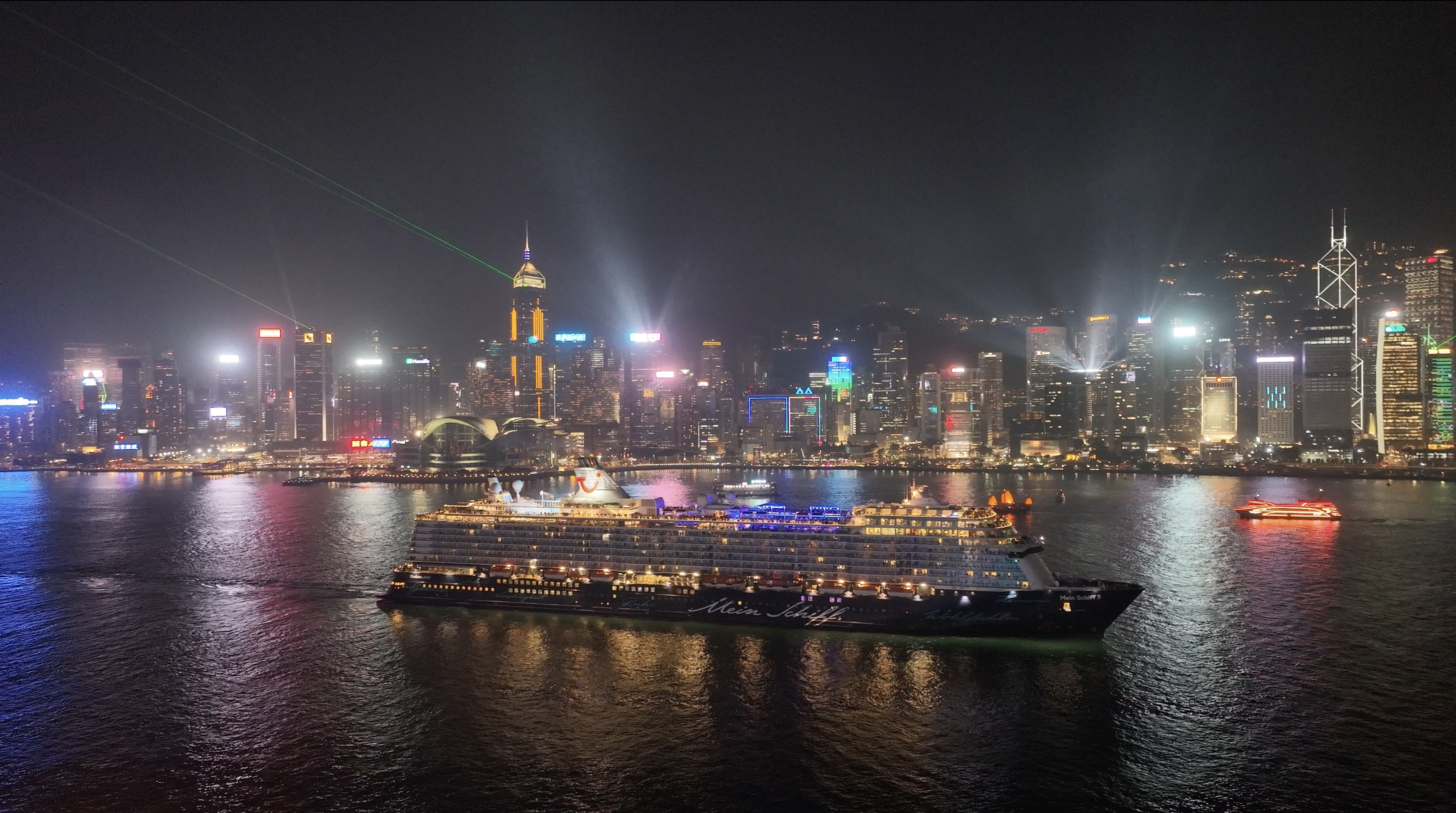 Nighttime view of Hong Kong skyline with a cruise ship in the harbor