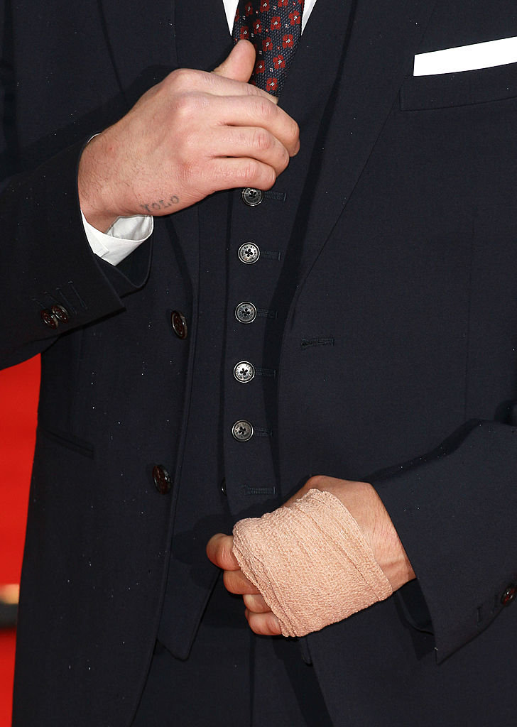 Zac&#x27;s small &quot;YOLO&quot; tattoo visible on his right hand as he adjusts his suit