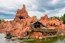 View of a Big Thunder Mountain Railroad ride with a train descending, themed as a rugged red rock mountain