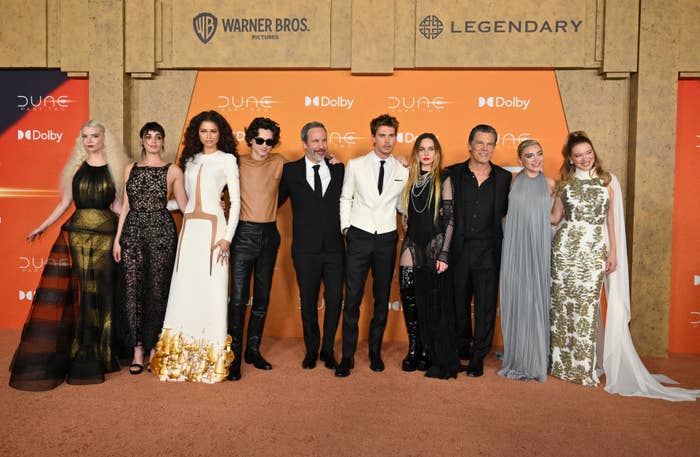 Cast of &quot;Dune&quot; posing at premiere, in formal attire, with logo backdrop