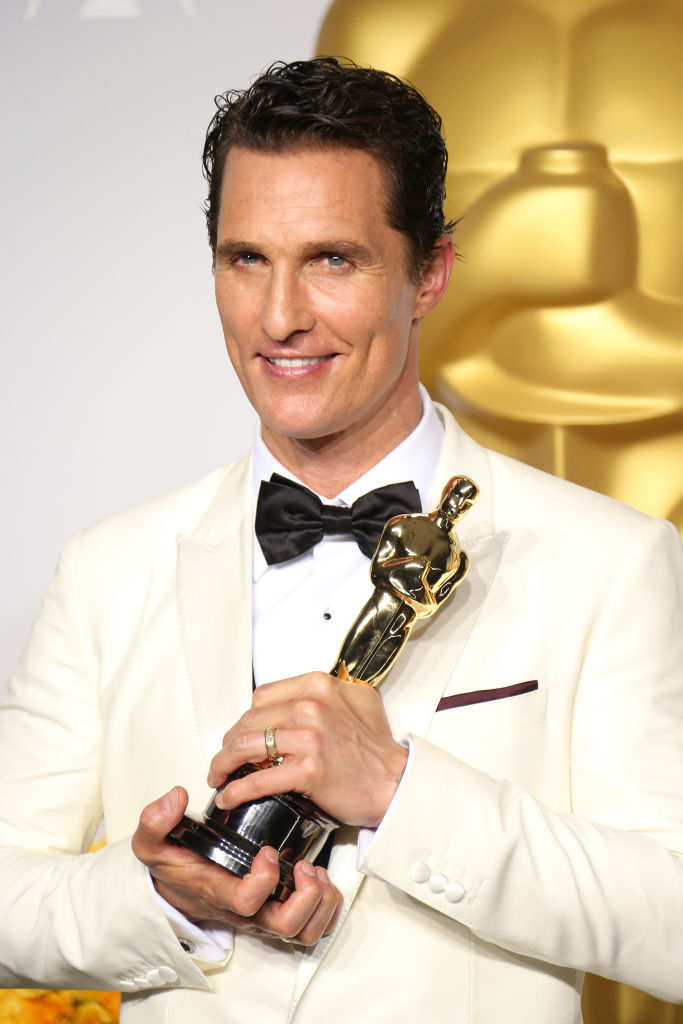 Matthew holding his Oscar, wearing a jacket and bow tie