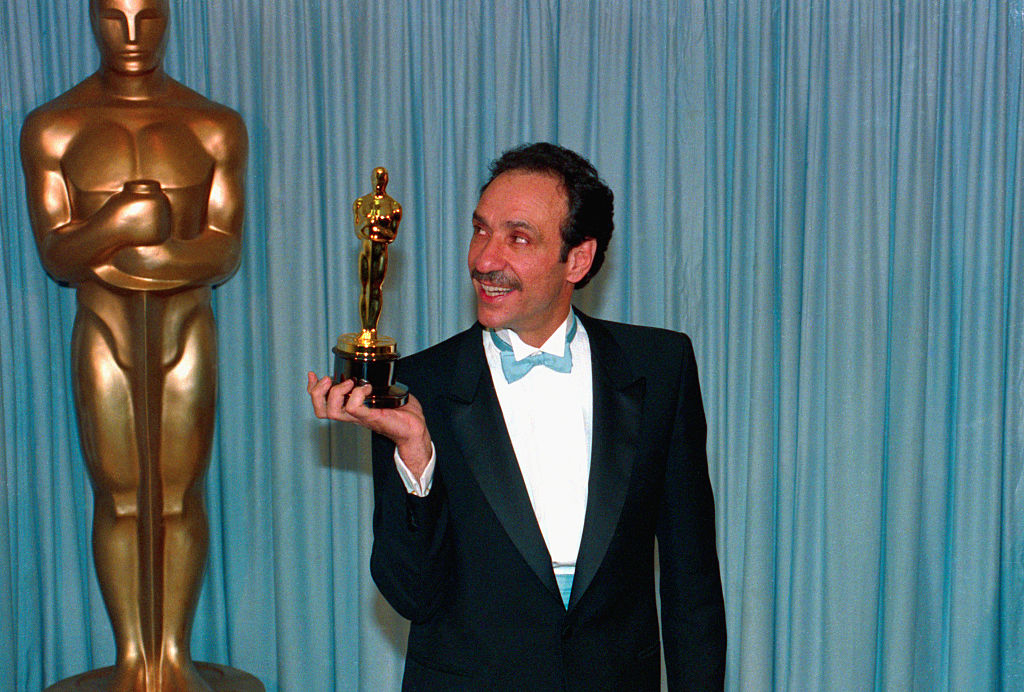 F Murray in a tuxedo with a bow tie smiling and holding an Oscar statuette