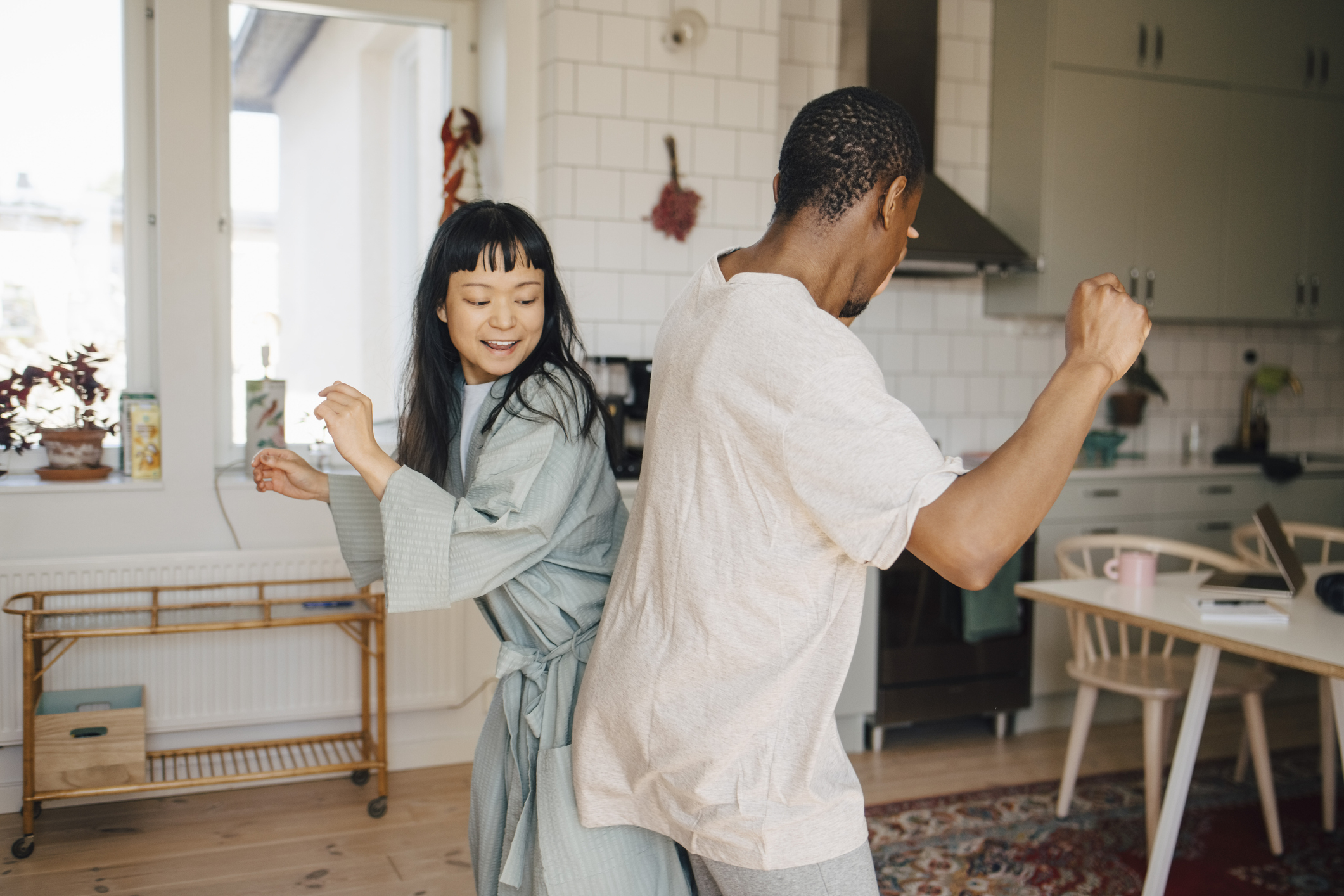 Two people joyfully dancing in a kitchen