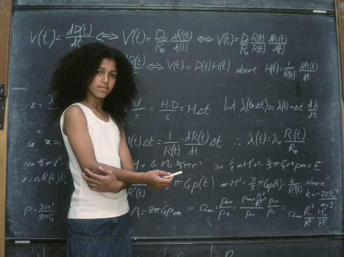 Young person stands in front of a blackboard filled with advanced mathematical equations, looking thoughtful