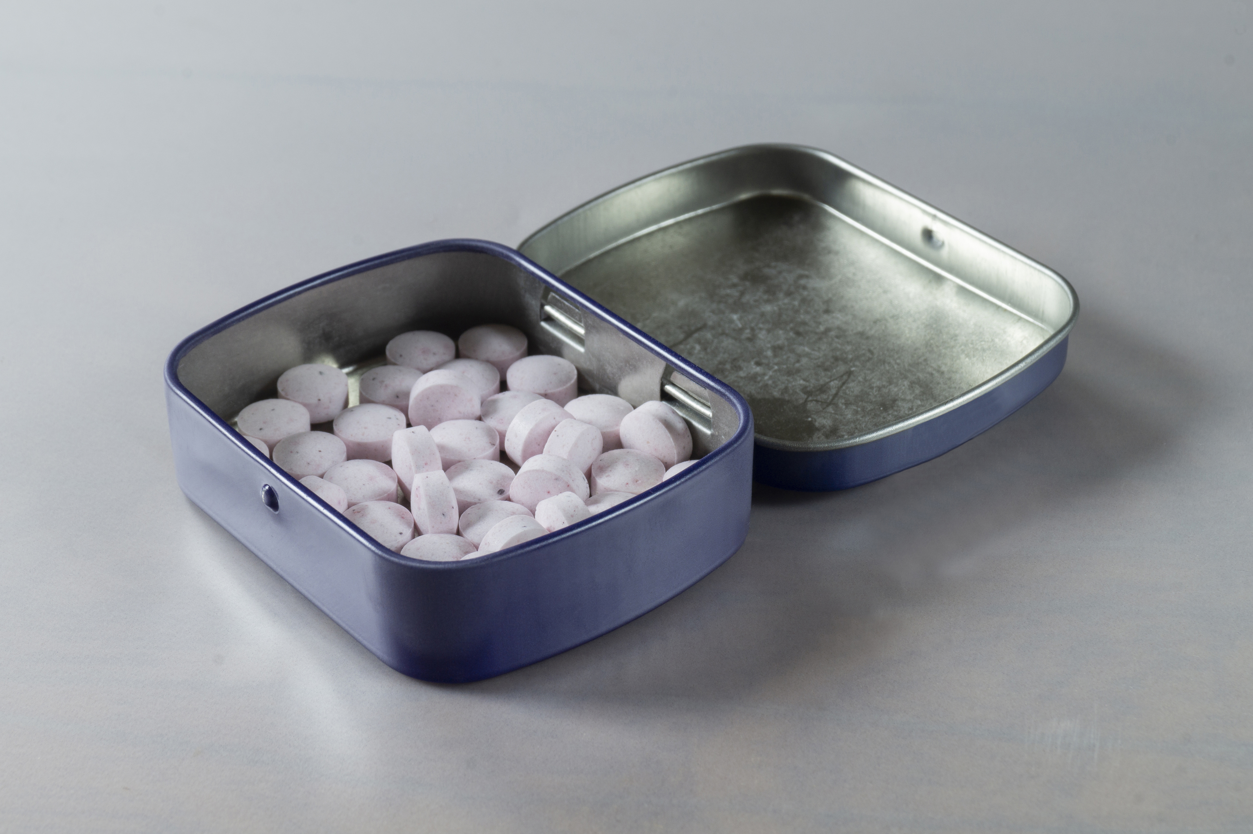 A tin of mints half-opened on a table