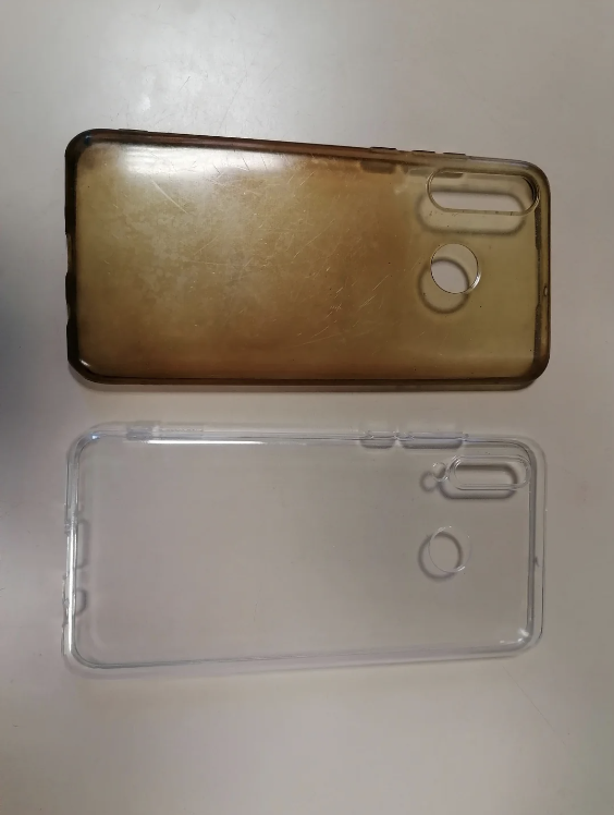 Two smartphone cases, one clear and one opaque with wear, on a surface