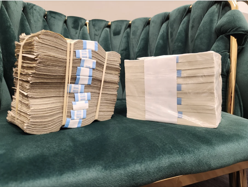 Two stacks of money bands on a green sofa, implying financial planning for parents