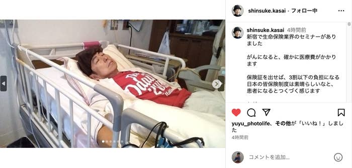 病院のベッドに横たわる患者（特定の名前なし）が写っている写真です。患者は「がんばろう東日本」と書かれたTシャツを着用しています。