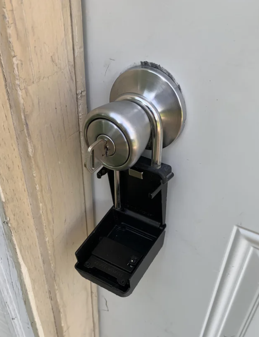 Key lockbox mounted on a door, open and empty