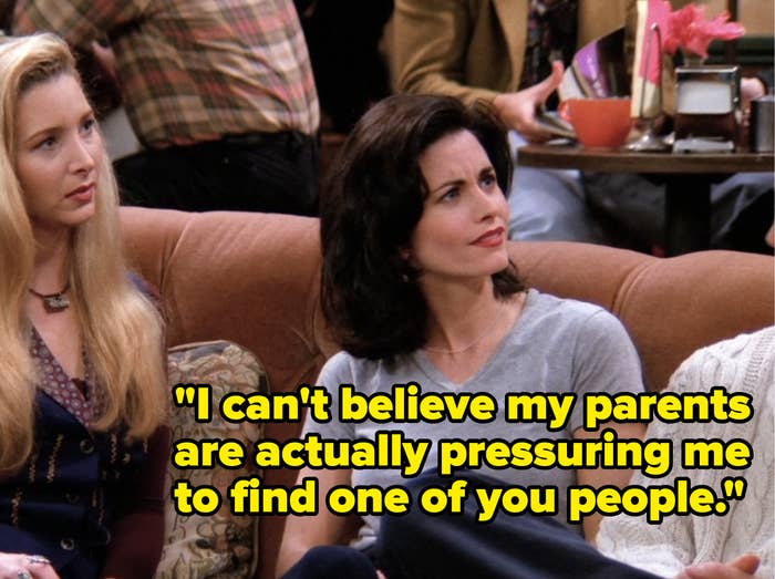 Phoebe and Monica from Friends sit on the couch in Central Perk engaged in conversation