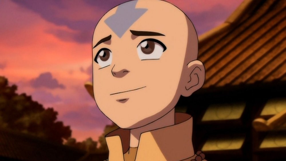 Animated character Aang from Avatar: The Last Airbender smiles with a temple in the background