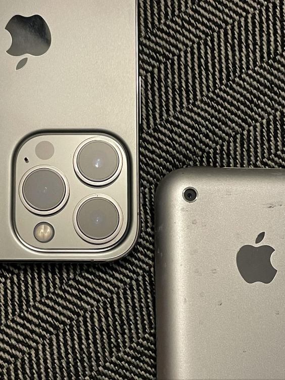 Two Apple iPhones of different models lying on a patterned surface