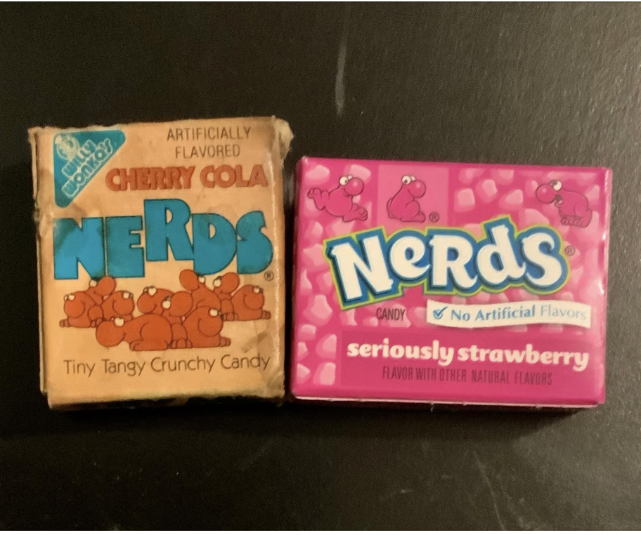 Two boxes of Nerds candy, one cherry cola flavored and one seriously strawberry flavored