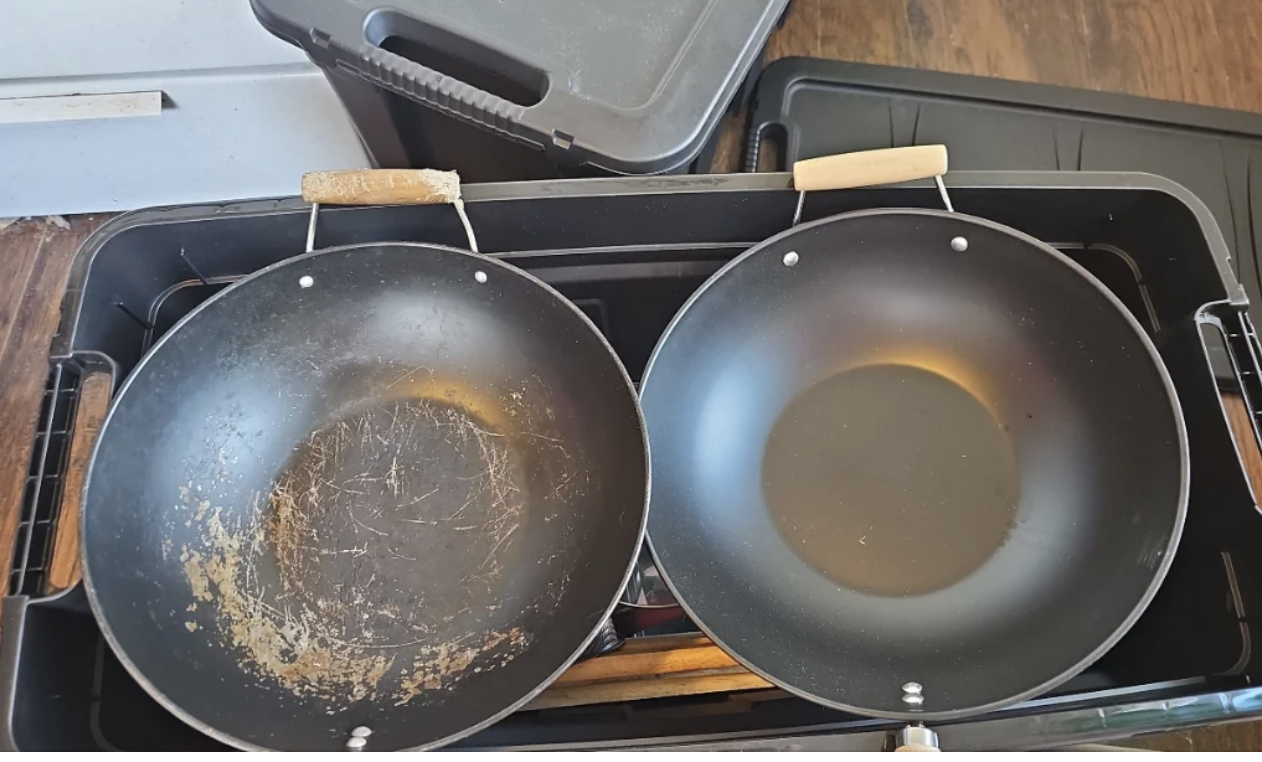 Two frying pans on a stove, one appears well-used with scratches, the other is newer