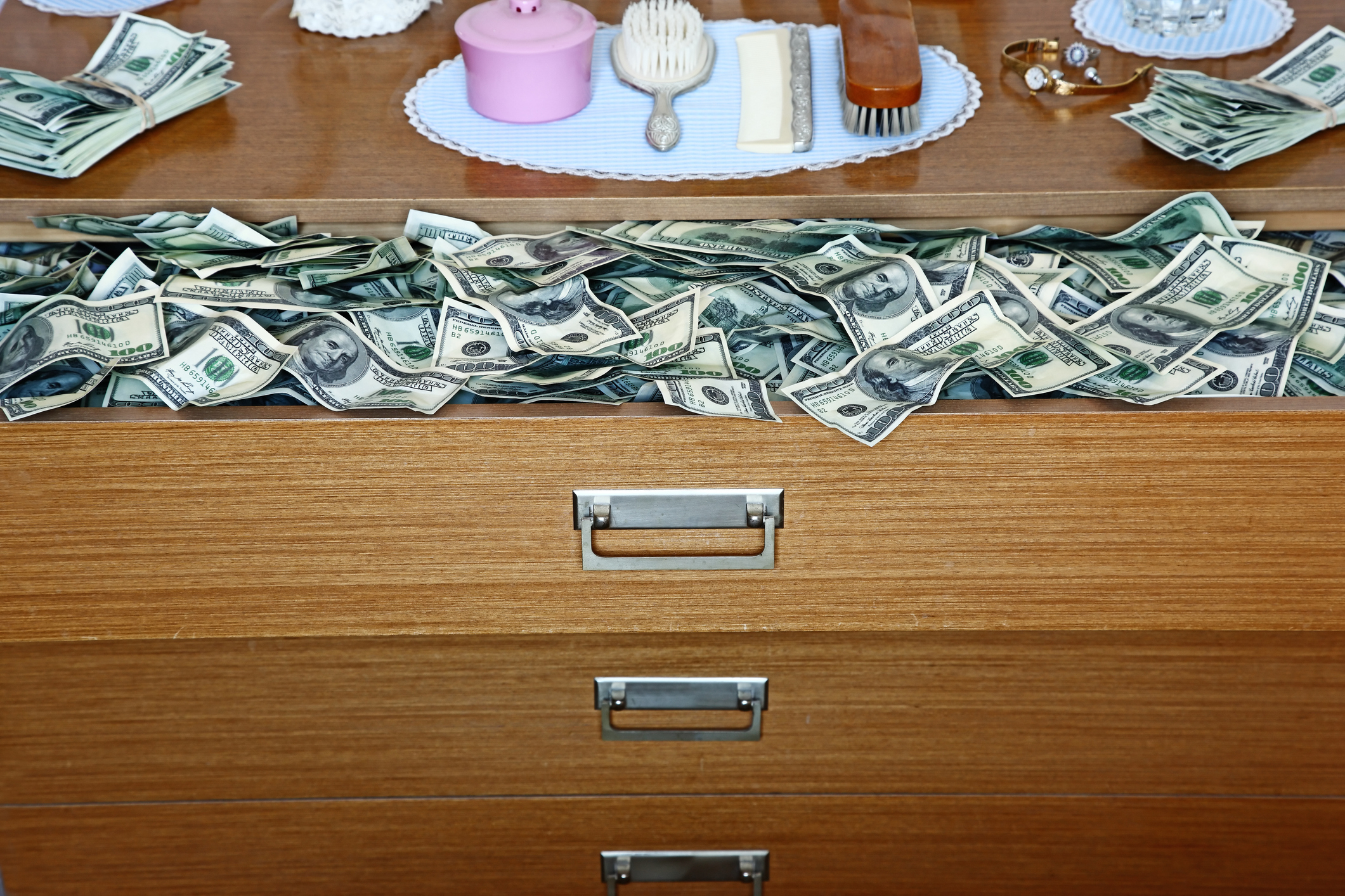 Drawers with cash sticking out, suggesting hidden wealth or savings
