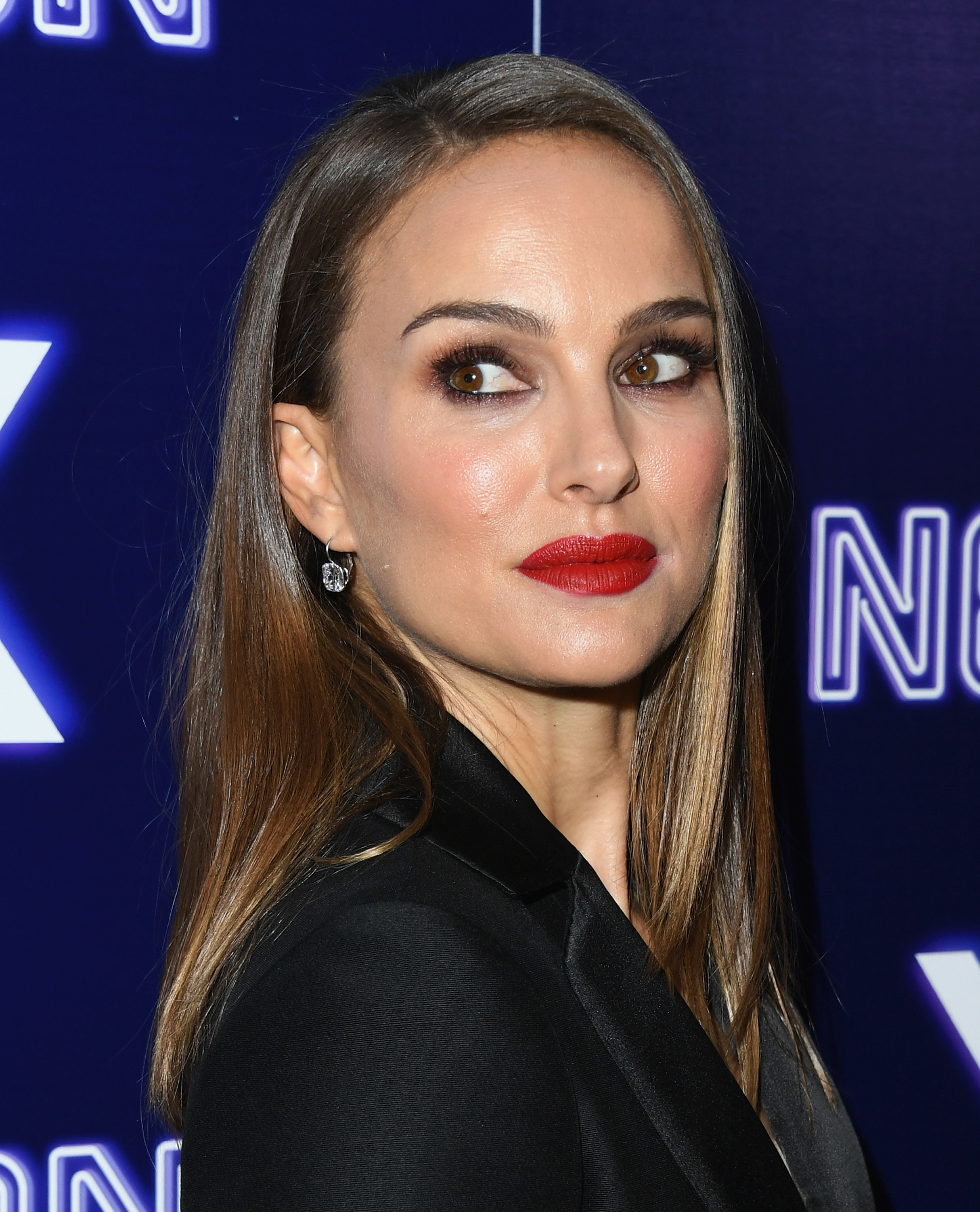 Natalie Portman in a sleek black outfit with straight hair at an event