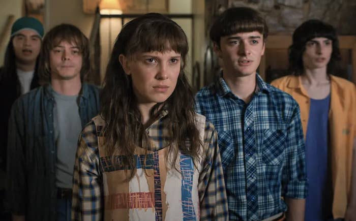 Five characters from the show &quot;Stranger Things&quot; standing together, looking intently ahead