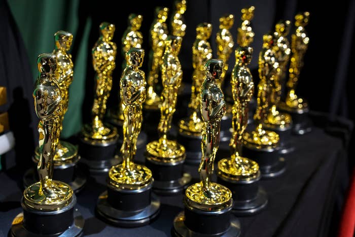 Multiple Oscar statuettes lined up on a table ahead of an awards ceremony