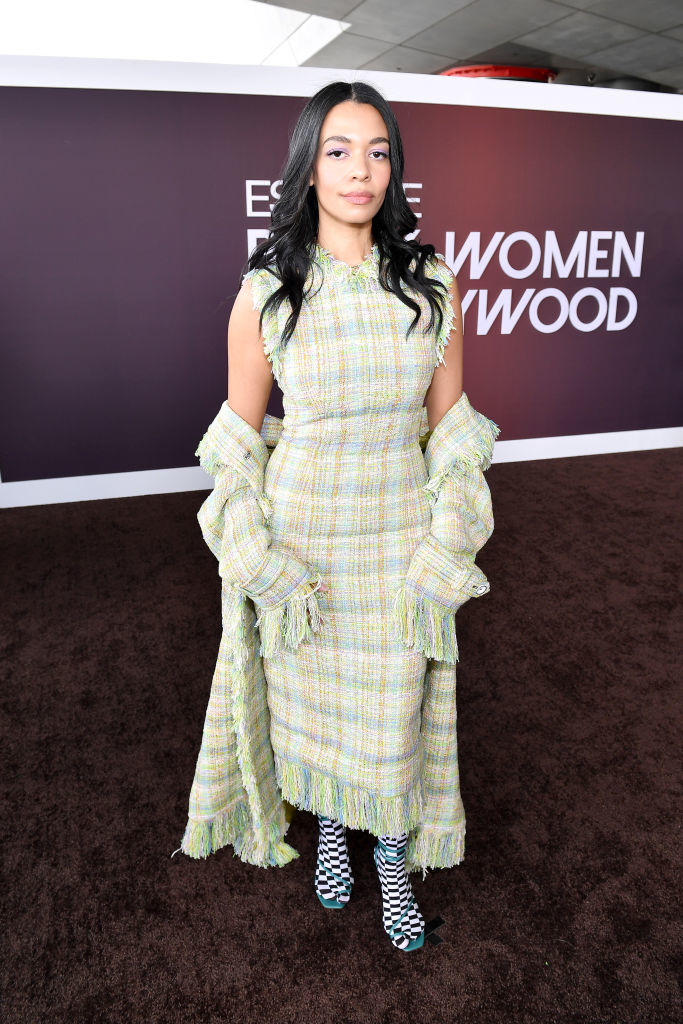 Aurora in a checkered tweed dress with fringes and matching tasseled jacket