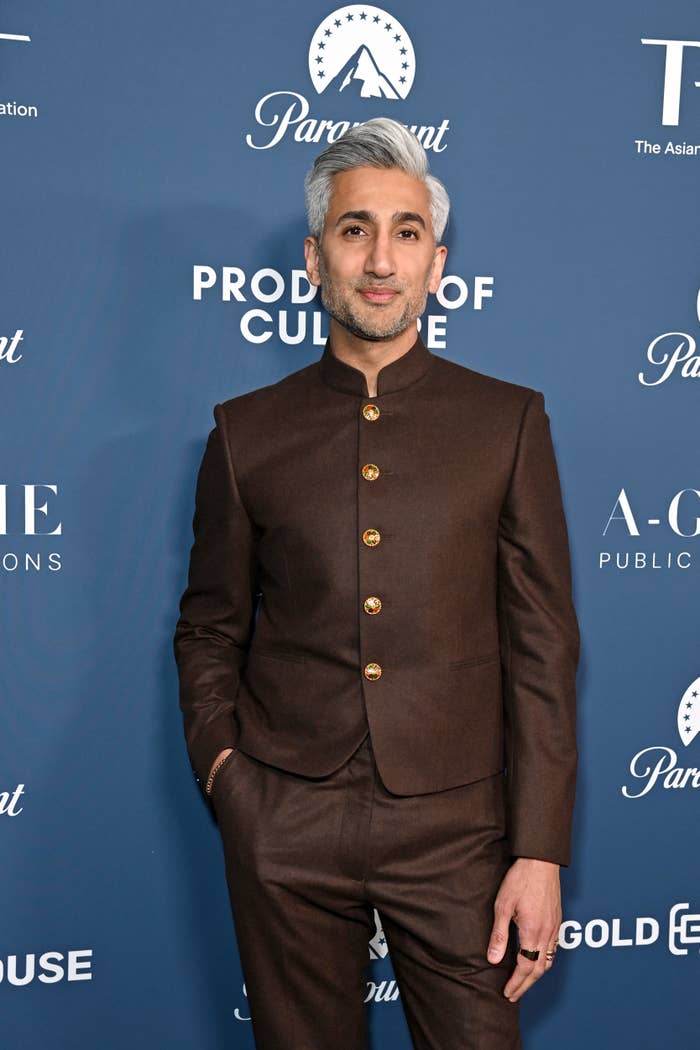 Tan France poses in a buttoned suit jacket at an event