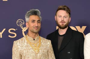 Four men posing at the Emmys; one in a traditional patterned outfit, two in suits, and one in a tuxedo with a medal
