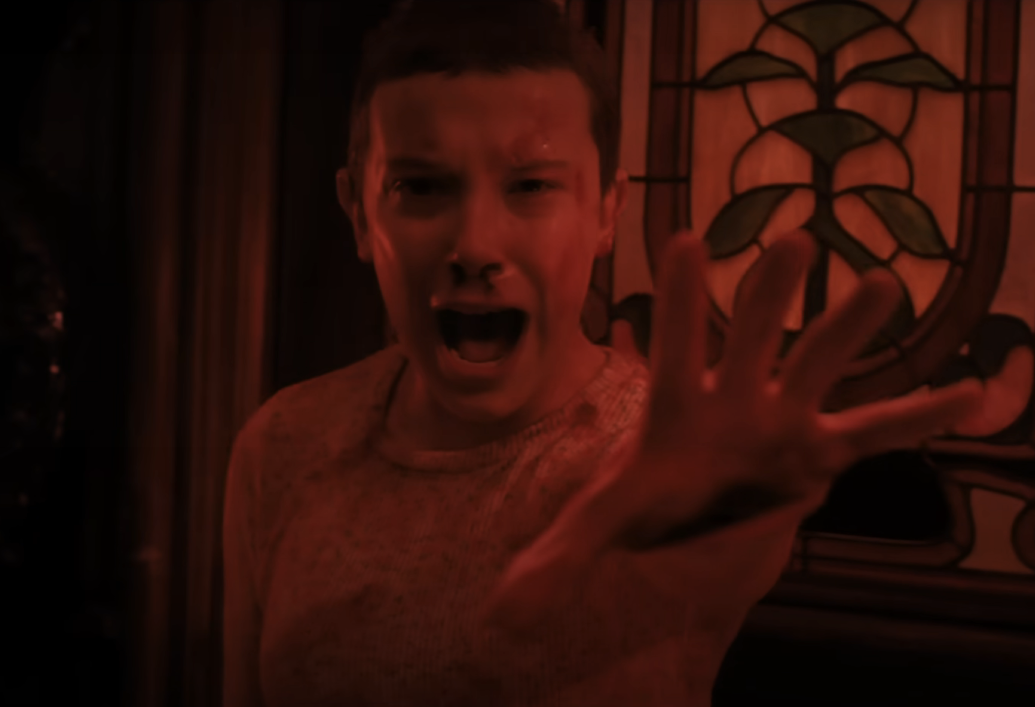 Millie Bobby Brown as Eleven in Stranger Things screaming with her hand outstretched
