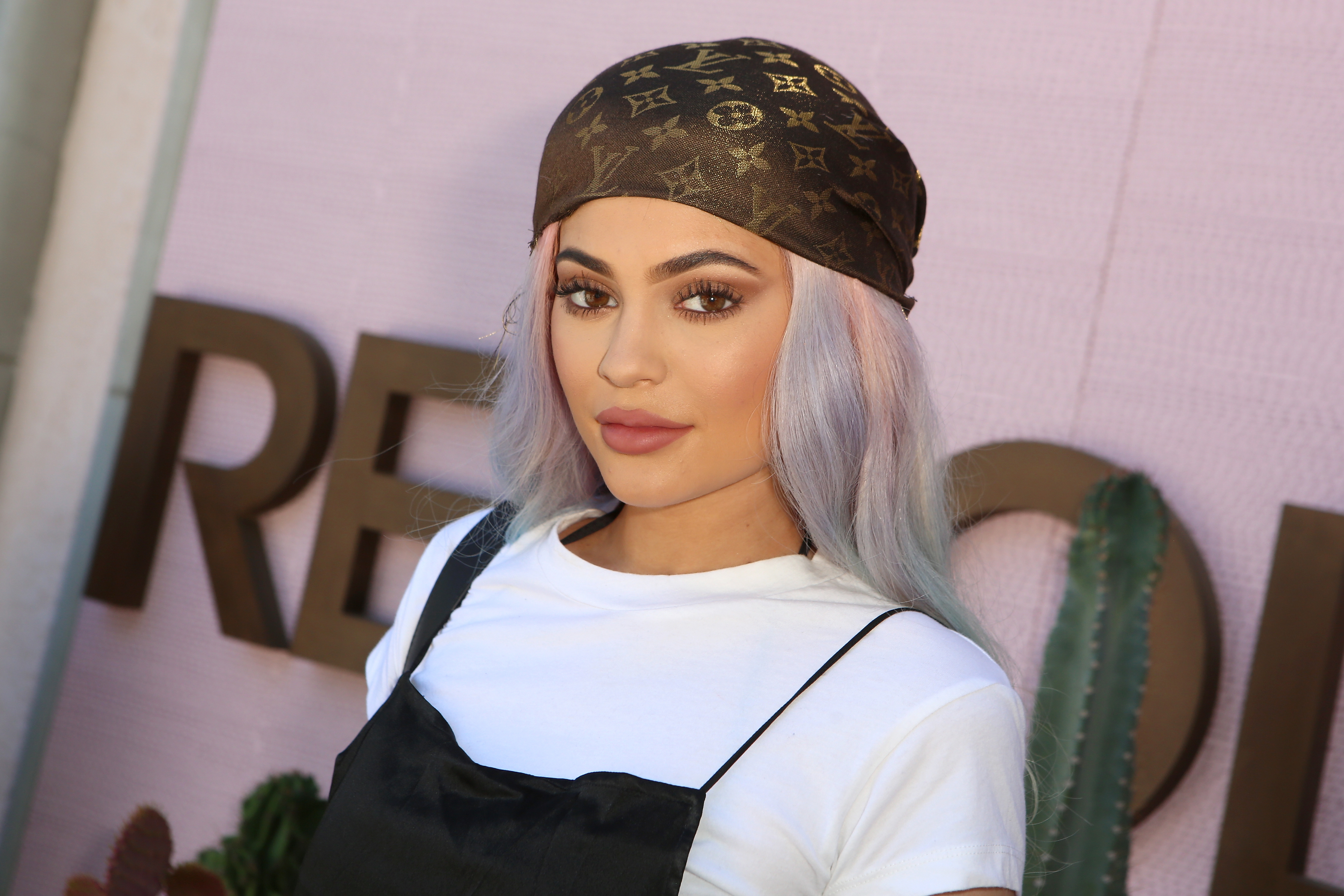 closeup of kylie with colorful hair under a LV headscarf