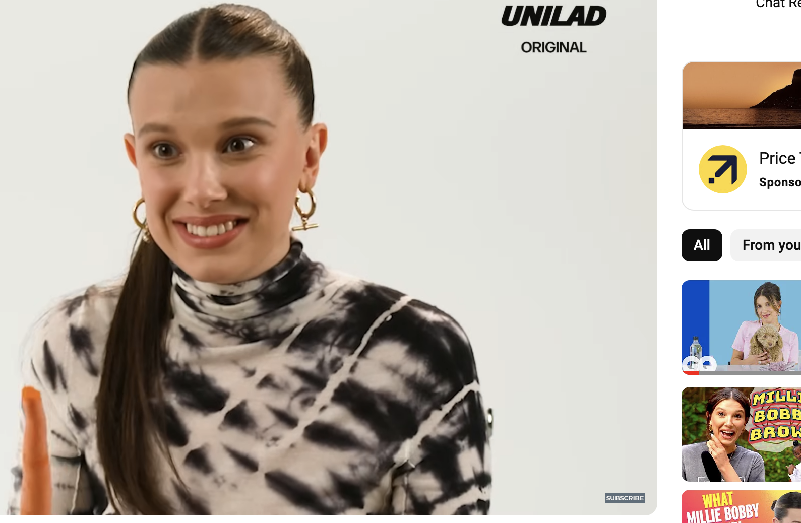Millie Bobby Brown smiling in a spotted top, holding a carrot