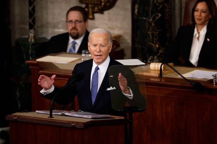 President speaking at a podium with officials seated behind him