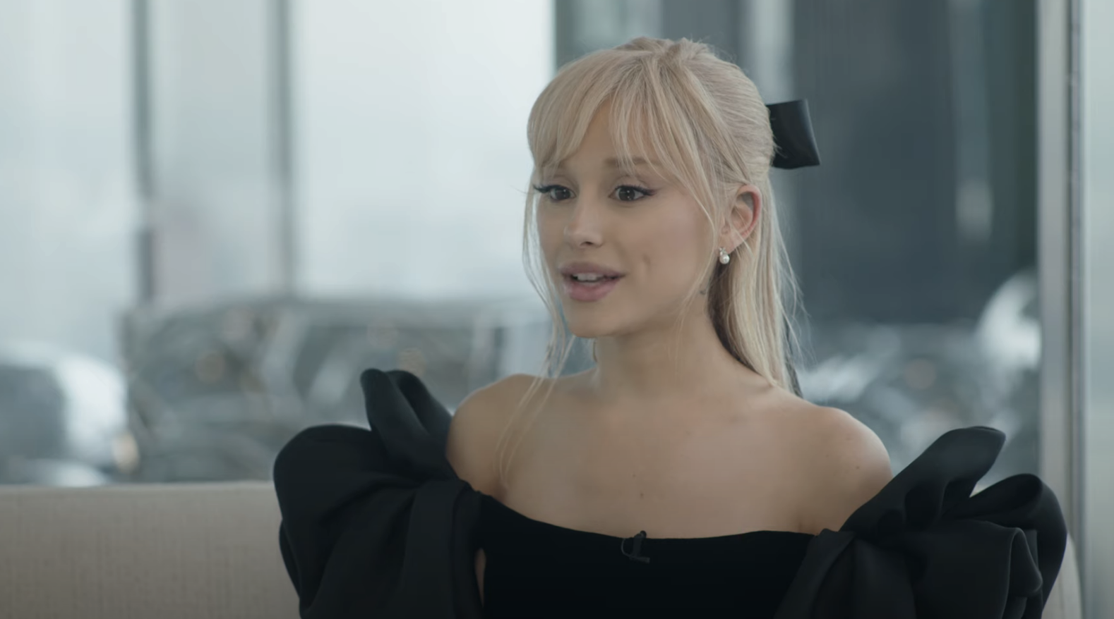 closeup of ariana in a dress and bleached hair in a bow