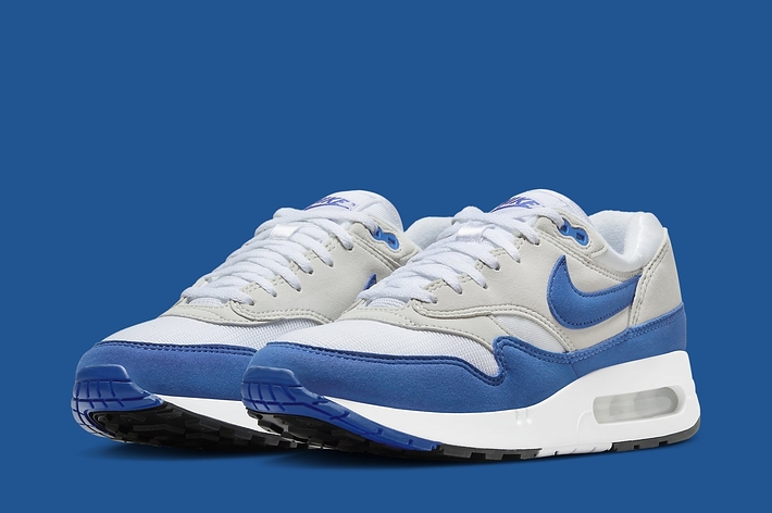A pair of Nike Air Max 1 sneakers with blue accents on a blue background