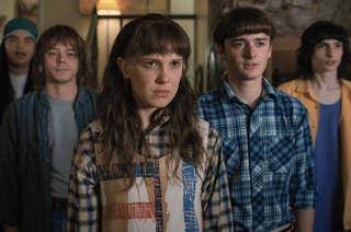 Five characters from the show 'Stranger Things' standing together, looking intently ahead