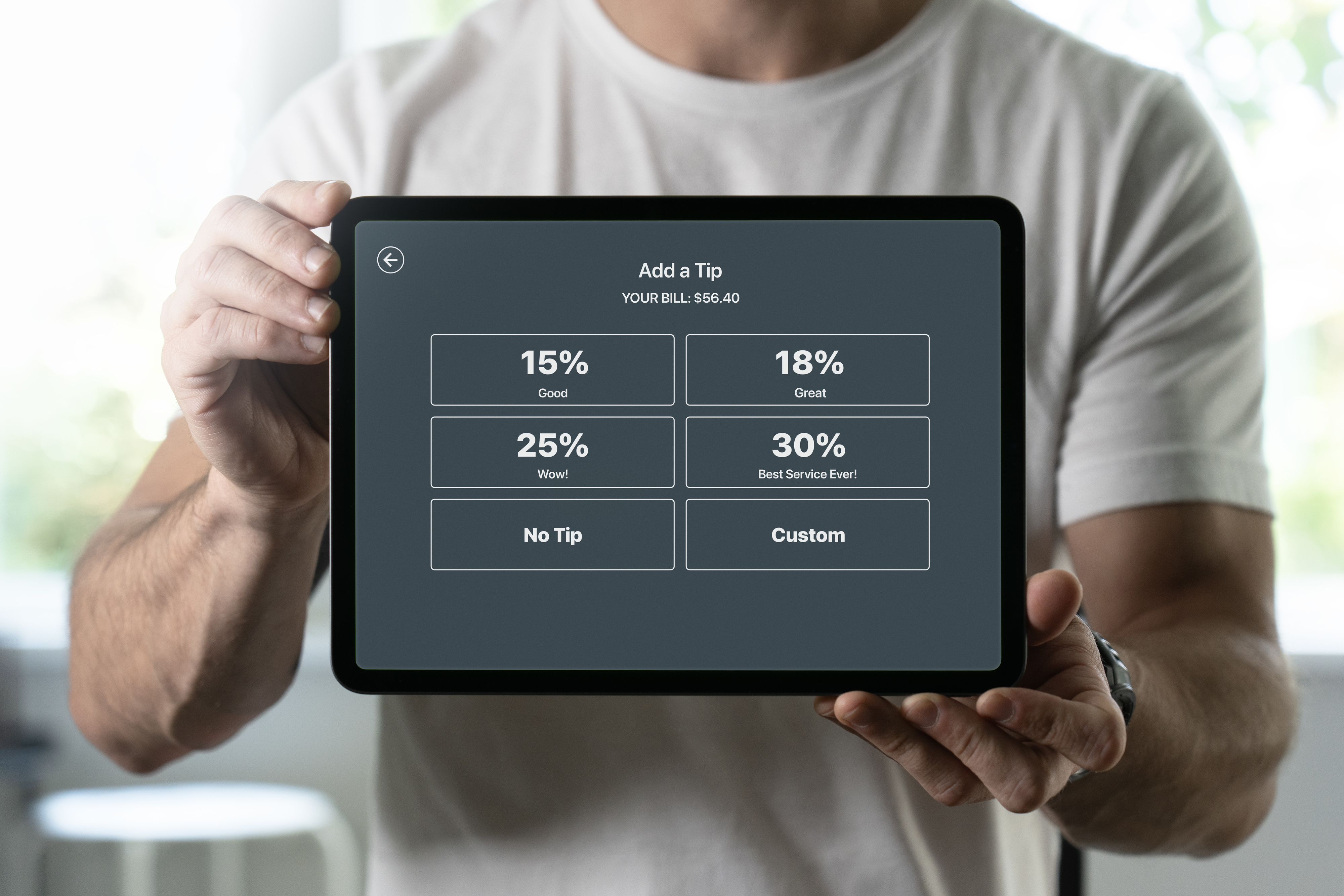 A person holding a tablet with a tipping option screen, including choices of 15%, 18%, 25%, 30%, No Tip, and Custom