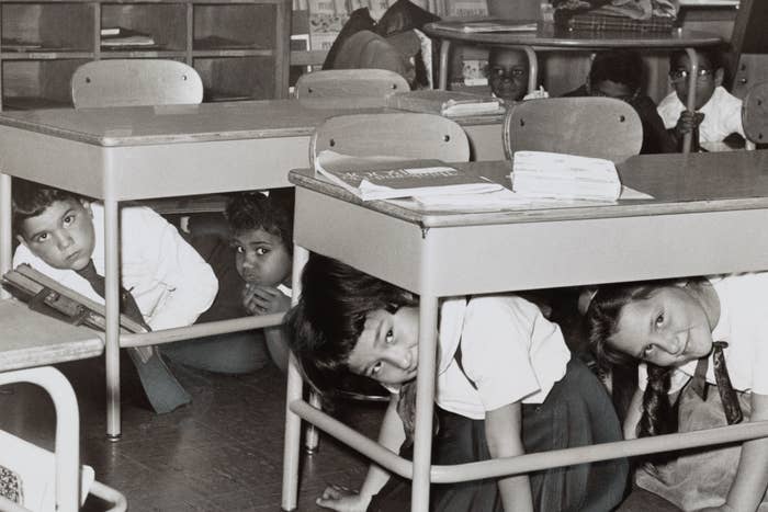 Children hiding under school desks during a drill