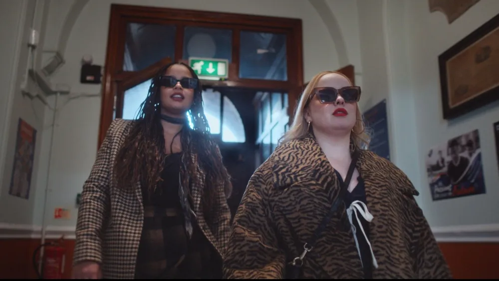 The cast of Big Mood walking through a hallway with sunglasses on